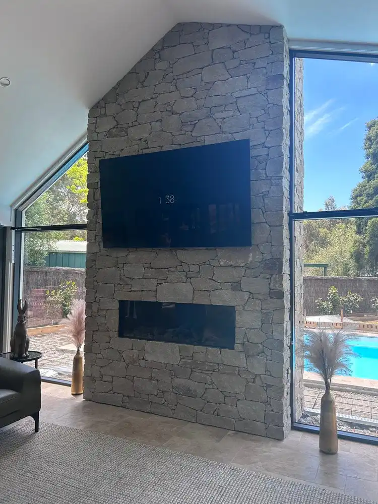 Stone fireplace with television